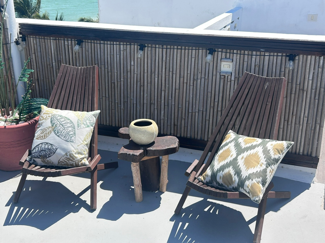 Two wooden lounge chairs in a quiet rooftop corner