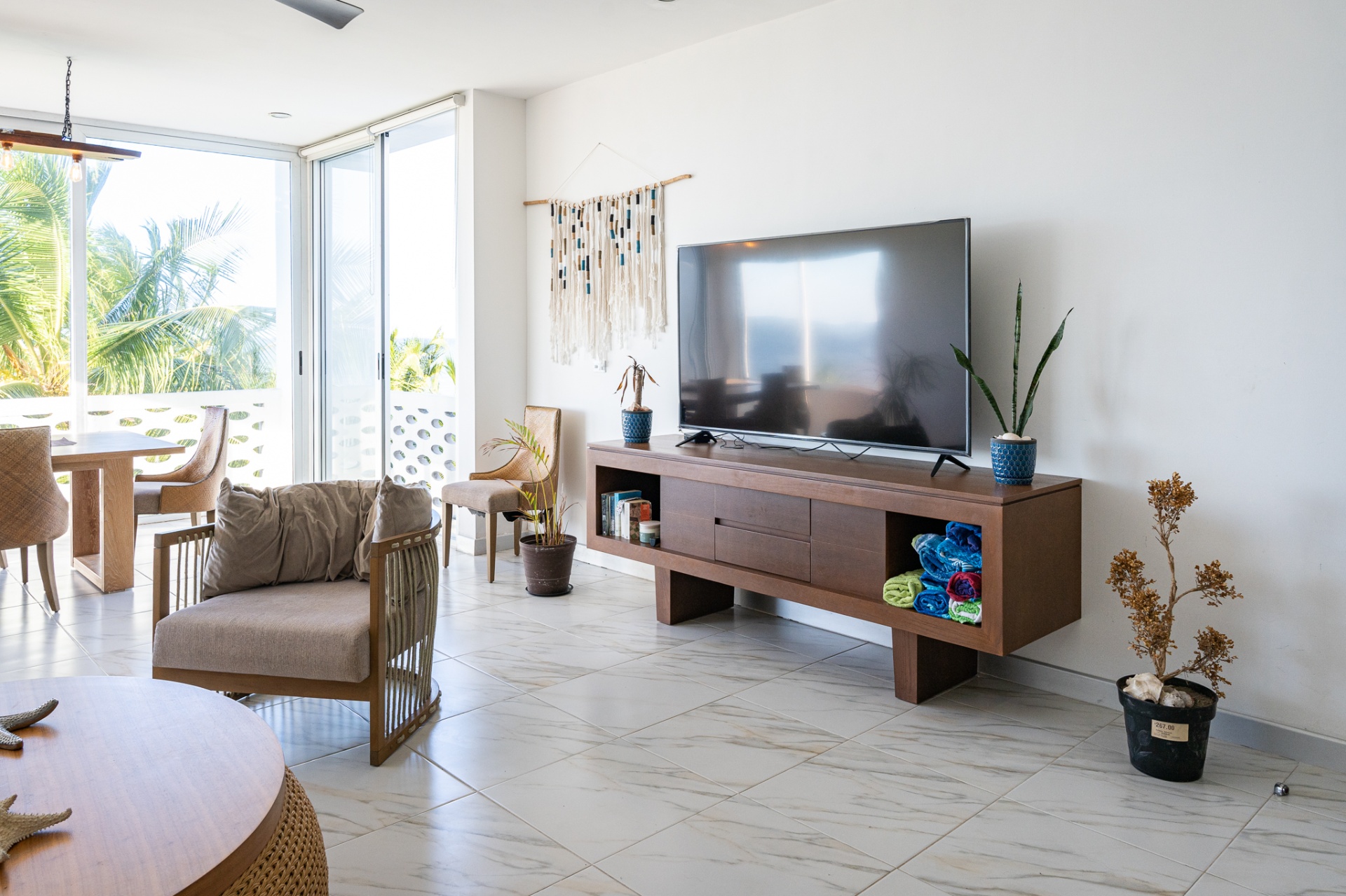 Bright living room with marble floors and palm-framed terrace